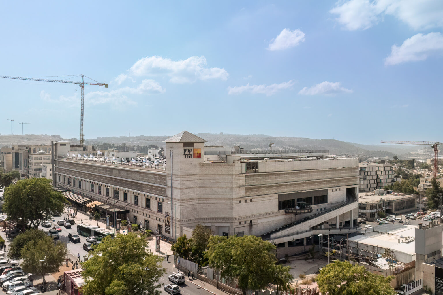 צילום חוץ מבנה עם שלט ״קניון הדר״ מכוניות ואנשים