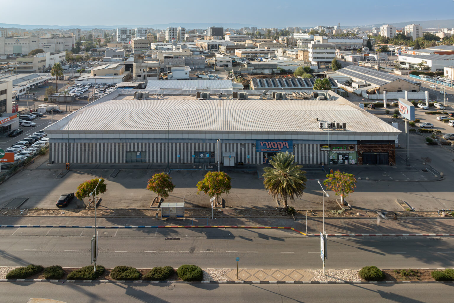 צילום חוץ של מבנה מסחרי עם השלט ״ויקטורי״, וכבישים